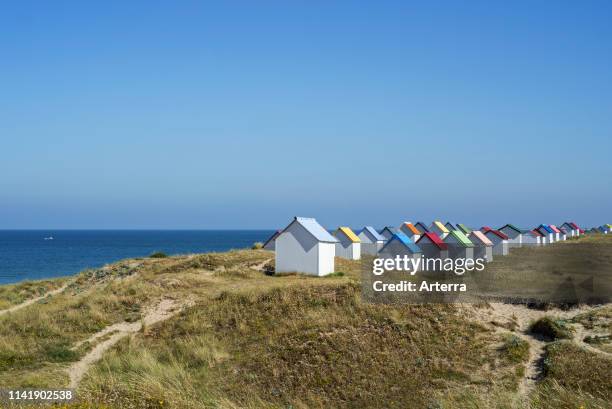 Row of colourful beach cabins in the dunes at Gouville-sur-Mer, Lower Normandy, France.