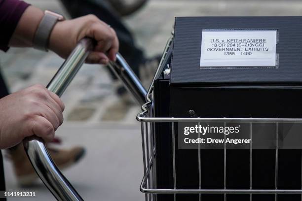 Staff and members of the prosecution team push carts full of court documents related to the U.S. V. Keith Raniere case as they arrive at the U.S....