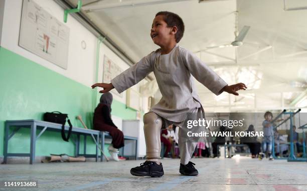 Ahmad Sayed Rahman, a five-year-old Afghan boy who lost his right leg when he was hit by a bullet in the crossfire of a battle, dances with his...