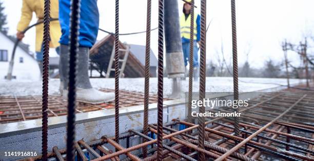 construction workers pouring cement on roof - metallic shoe stock pictures, royalty-free photos & images