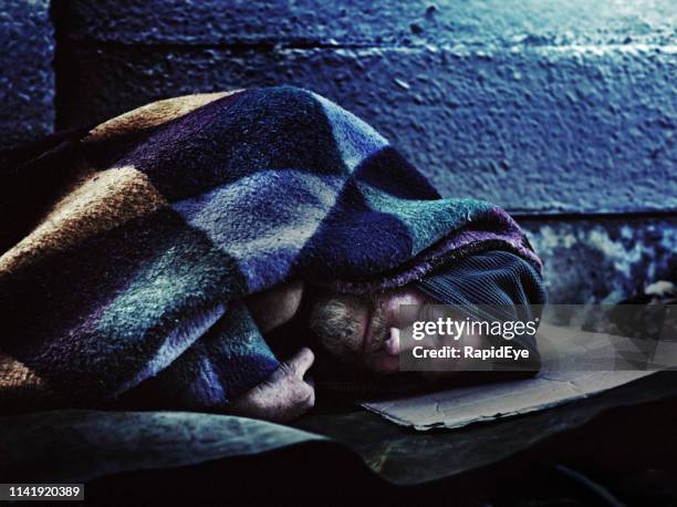 dakloze man slapen op de stoep - homelessness stockfoto's en -beelden