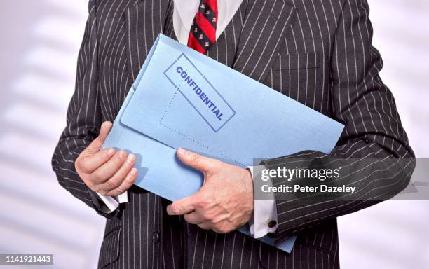 businessman holding confidential top secret folder - confidential englischer begriff stock-fotos und bilder