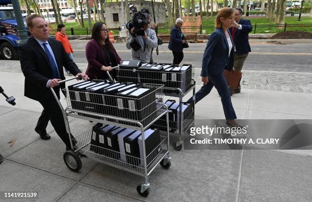 Members of the prosecution in the Nxivm case arrive with documents at Brooklyn Federal Court on May 7 for day one of the trial of Keith Raniere,...