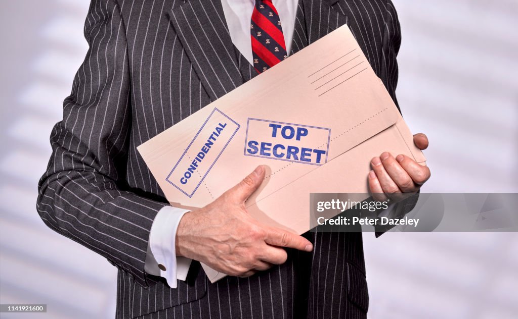 Businessman holding Confidential Top Secret Folder
