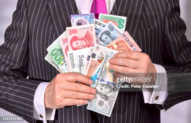 businessman holding a selection of banknotes - stock of japanese yen and us dollars ahead of british eu referendum vote stockfoto's en -beelden