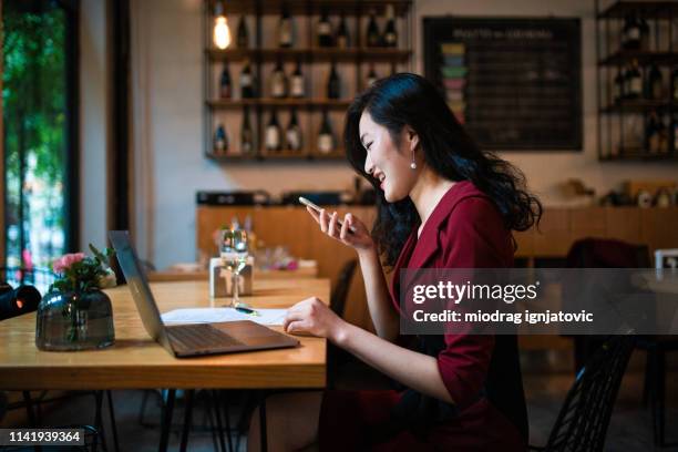 chinese woman sending voice message - speech recognition stock pictures, royalty-free photos & images