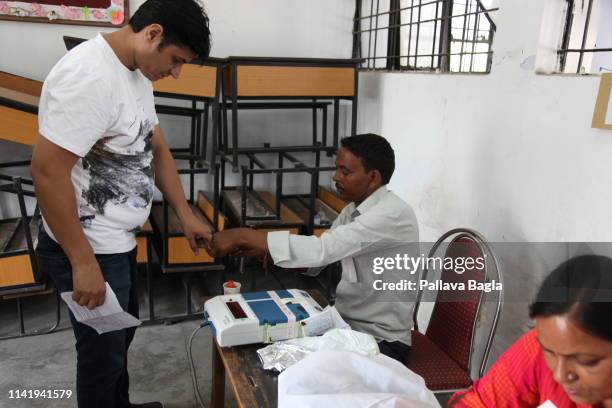 One of the 900 million voters awaits his turn to cast his vote on the electronic voting machine. India follows secret balloting so the voting unit...