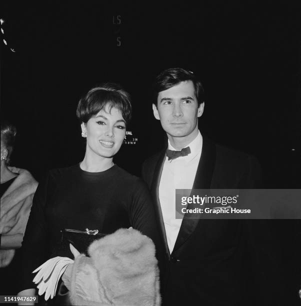 American actor and singer Anthony Perkins with American actress Charlene Holt at the premiere of 'Becket', US, 1964.
