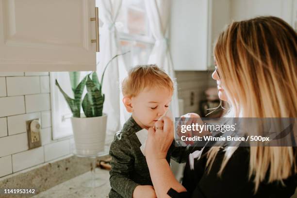 sneezing boy and his mom - sneeze stock pictures, royalty-free photos & images