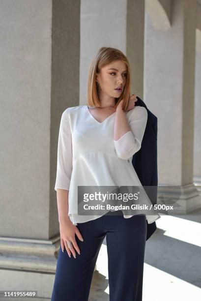 close up portrait of redhead woman standing by pillar - women in see through tops stock pictures, royalty-free photos & images