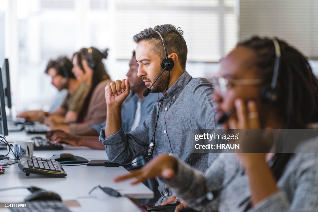 Executivo que escuta a pergunta do cliente em auriculares