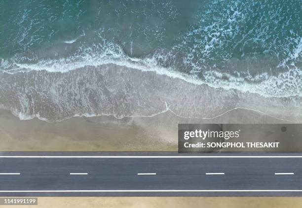 aerial view/the road along the beach by the sea with beautiful waves - divisória de pista imagens e fotografias de stock