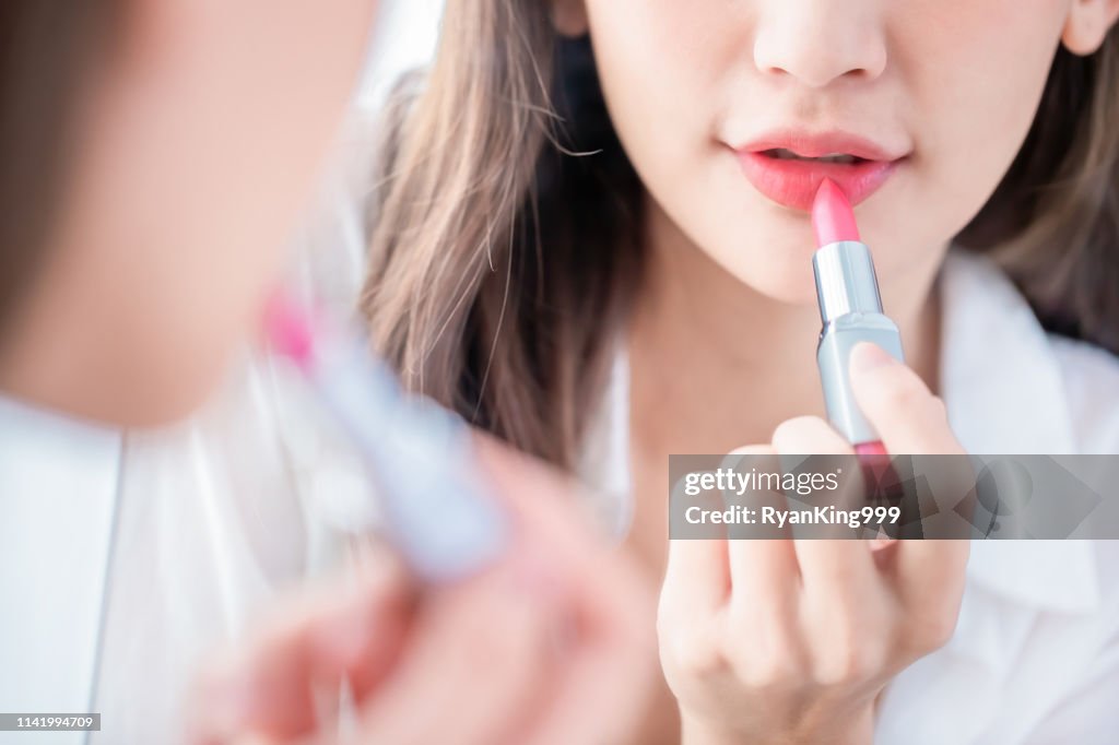 Mujer aplicando lápiz labial