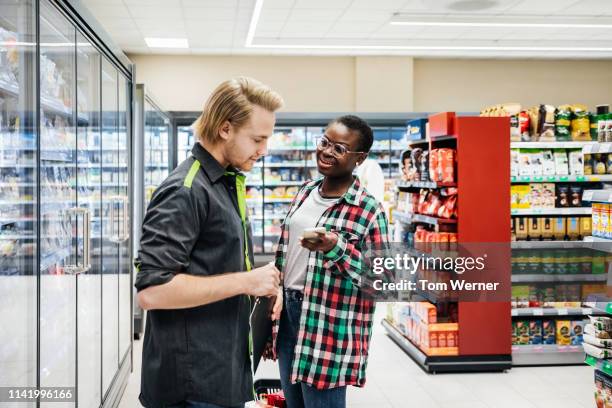 grocery store clerk assisting girl with query - manquestionmark stock pictures, royalty-free photos & images