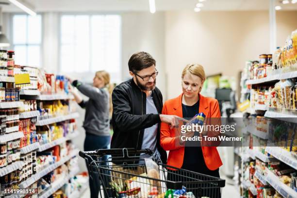mature couple reading nutrition label on food item - voedingslabel stockfoto's en -beelden