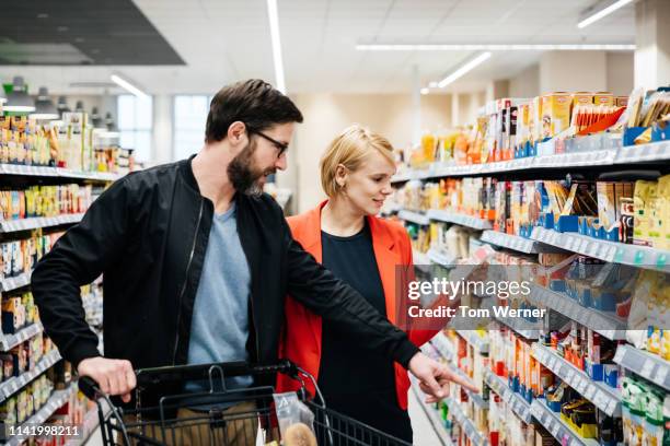 mature couple reading nutrition labels while grocery shopping - tag 2 fotografías e imágenes de stock