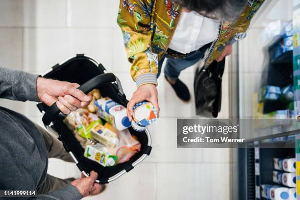 aerial view of senior couple picking out groceries - cesta de compras fotografías e imágenes de stock
