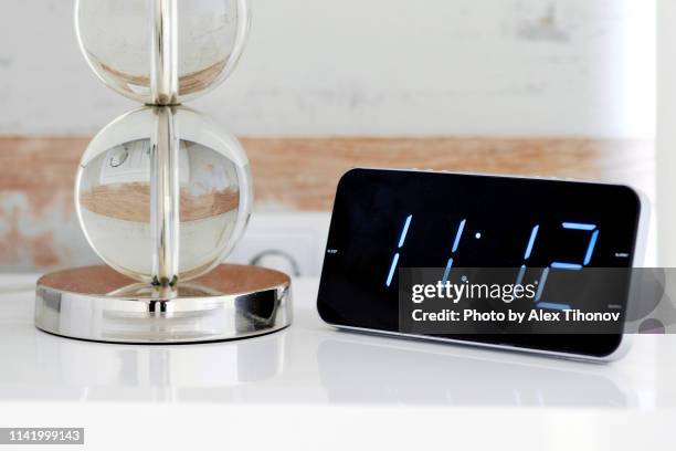 digital alarm clock, blue digits over black background - alarm clock stock-fotos und bilder