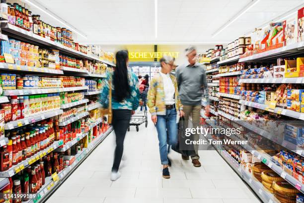 busy supermarket aisle with customers - supermarktgang stock-fotos und bilder