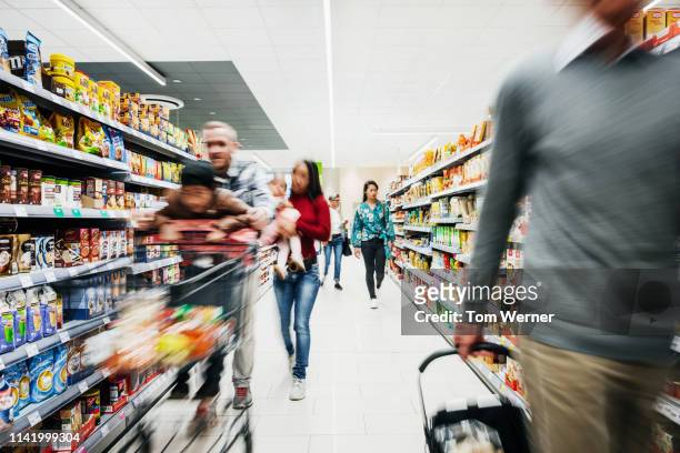 busy supermarket aisle with customers - consumerism foto e immagini stock