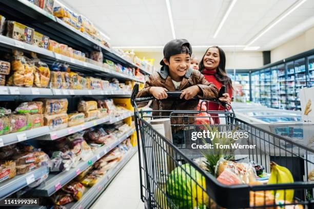 family having fun while out buying groceries. - retail stockfoto's en -beelden