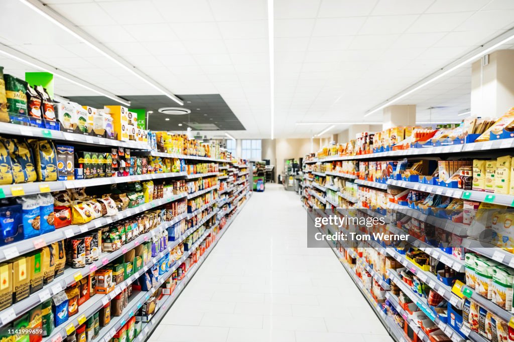 An Empty Supermarket Aisle Filled With Stock