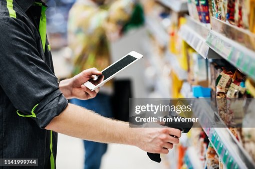 Supermarket Employee Using Tablet And Bar Code Reader Supermarket Employee Using Tablet And Bar Code Reader