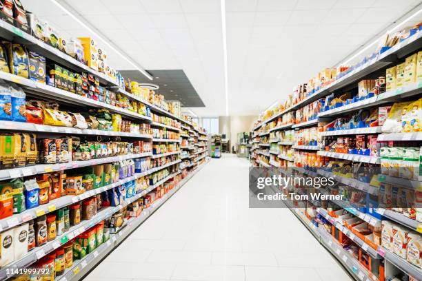 a colorful supermarket aisle - empty supermarket shelves photos et images de collection