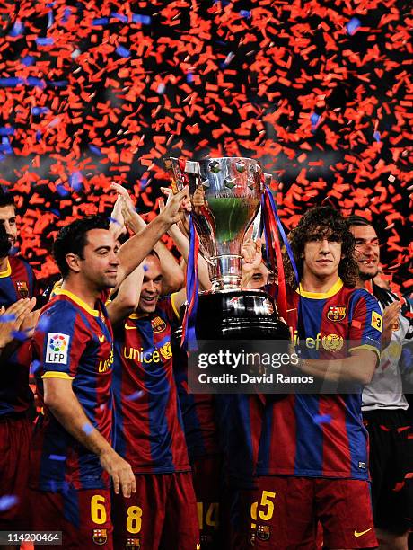 Xavi Hernandez and Carles Puyol of FC Barcelona hold aloft the La Liga trophy after the La Liga match between Barcelona and Deportivo La Coruna at...