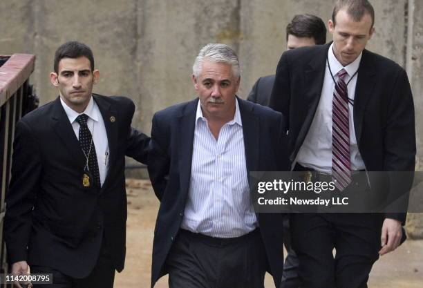 Former Suffolk County police chief James Burke is escorted to a vehicle by FBI personnel outside the FBI office in Melville, New York on December 9,...