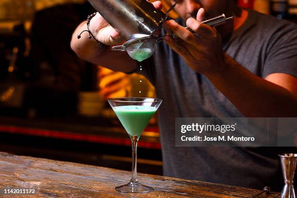 bartender filtering the mix from de shaker - chocolate bar foto e immagini stock