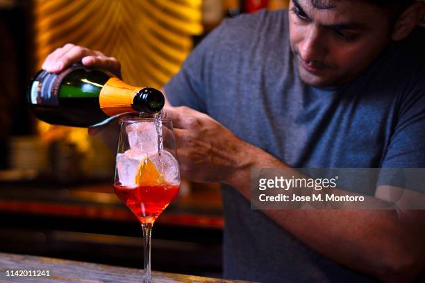 bartender preparing a spritz aperol with dugging - barman tequila stock pictures, royalty-free photos & images