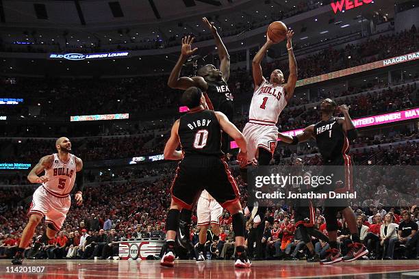 Derrick Rose of the Chicago Bulls attempts a shot against Mike Bibby, Joel Anthony and Chris Bosh of the Miami Heat in Game One of the Eastern...