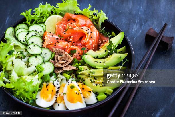 salmon poke bowl served with avocado, eggs, cucumber and greens - avocado salad stock pictures, royalty-free photos & images