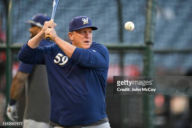 Bench coach Pat Murphy of the Milwaukee Brewers hits grounders during warmups before playing the Los Angeles Angels of Anaheim at Angel Stadium of...