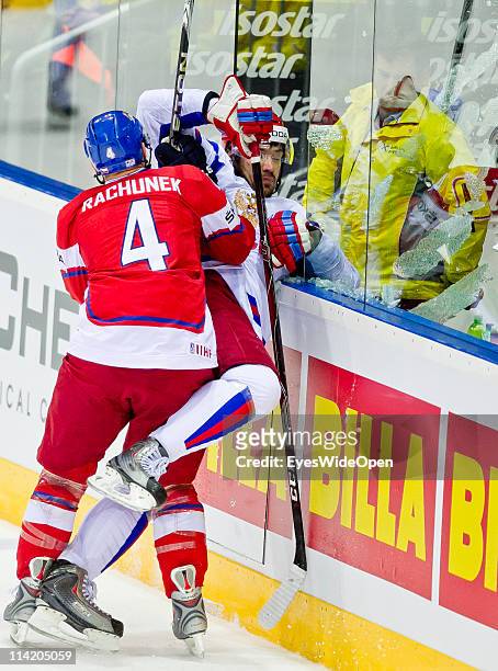 Karel Rachunek of Czech Republic tackles Yevgeni Artyukhin of Russia and breaks the safety glass during the IIHF World Championship bronze medal...