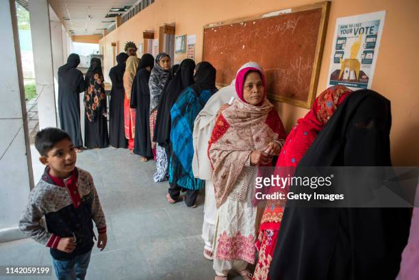 April 11: Kashmiri women wait in a queue to cast their ballots outside the polling station, during the first phase of the elections of the lower...