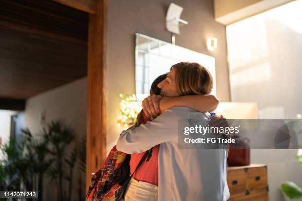 teenager gilr and mature woman embracing - visit grandmother stock pictures, royalty-free photos & images