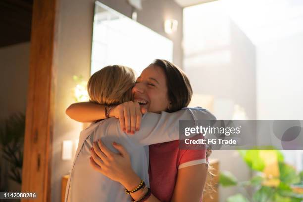 teenagr chica y mujer madura abrazando - reencuentro fotografías e imágenes de stock