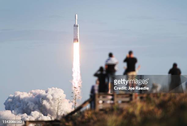 People watch as the SpaceX Falcon Heavy rocket lifts off from launch pad 39A at NASA’s Kennedy Space Center on April 11, 2019 in Titusville, Florida....