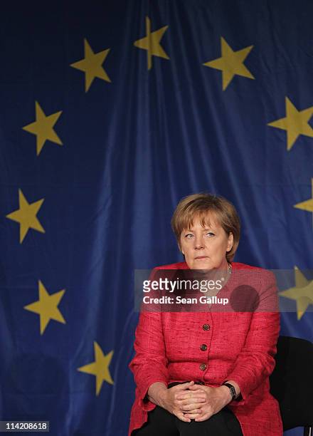 German Chancellor Angela Merkel sits in front of a flag of the European Union while visiting students at the Sophie Scholl school on the fifth...