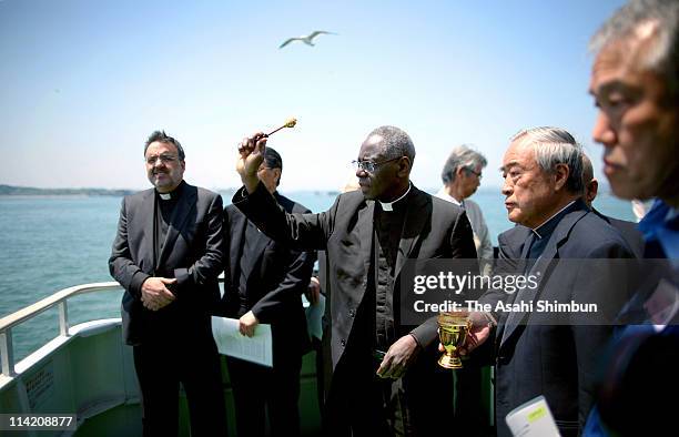 Cardinal Robert Sarah prays for the victims of the eartquake and tsunami on a boat on May 16, 2011 in Matsushima, Miyagi, Japan. The death toll has...