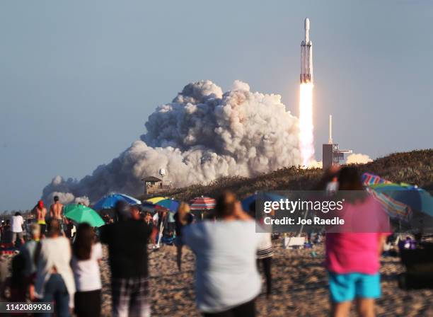 People watch as the SpaceX Falcon Heavy rocket lifts off from launch pad 39A at NASA’s Kennedy Space Center on April 11, 2019 in Titusville, Florida....