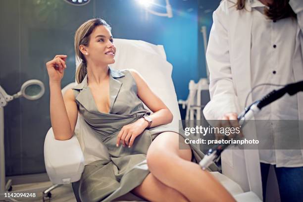 young woman on laser hair removal procedure - examining hair stock pictures, royalty-free photos & images