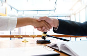 Lawyer or judge  with gavel and balance handshake with client