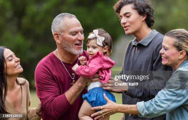 multi-generation hispanic family, grandpa holding baby - paparazzi x posed stock pictures, royalty-free photos & images