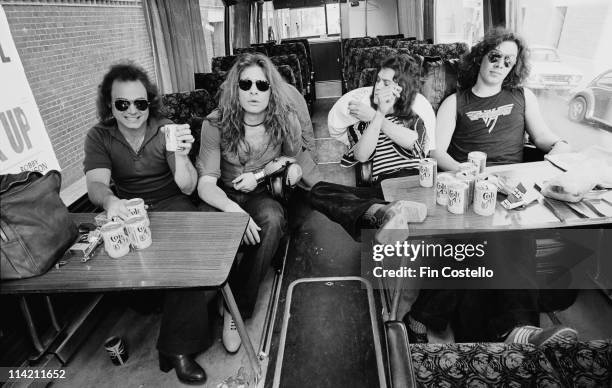 Van Halen pose in their their tour bus outside Lewisham Odeon in London on 27th May 1978. On the table in front of the band are various beer cans and...