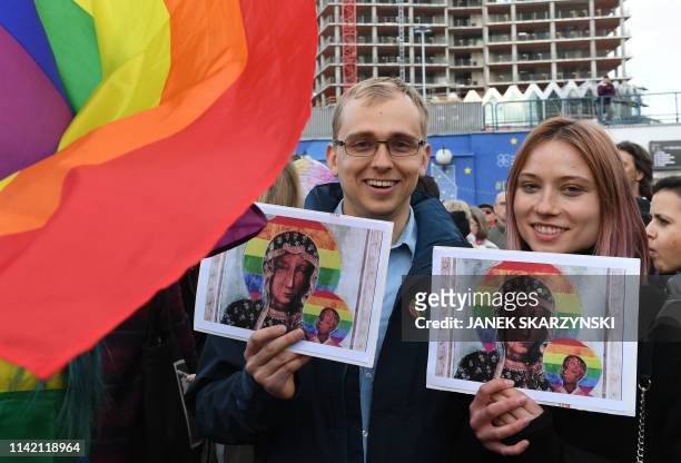 Protester hold rainbow flags and posters depicting the Virgin Mary with a rainbow halo during a rally for freedom of speech in downtown Warsaw on May...