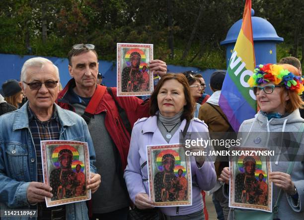 Protester hold rainbow flags and posters depicting the Virgin Mary with a rainbow halo during a rally for freedom of speech in downtown Warsaw on May...