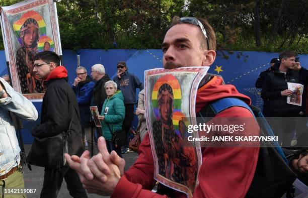 Protesters hold posters depicting the Virgin Mary with a rainbow halo during a rally for freedom of speech in downtown Warsaw on May 7, 2019 after a...